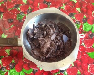 Breek de chocolade in stukjes in een metalen kom en smelt de chocolade ‘au bain marie’ boven een pan met heet water.