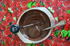 Neem de kom met gesmolten chocolade van de pan en af laten koelen door regelmatig door de chocolade te roeren. Controleer met de thermometer puur 31°C, melk en wit tussen 30 - 29°C.
